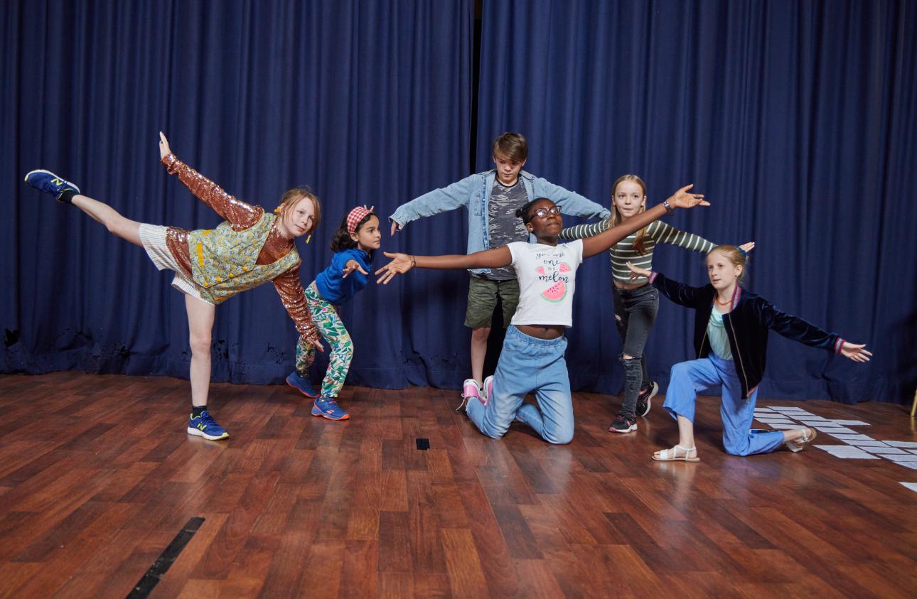 The group of young people rehearing and moving together their show