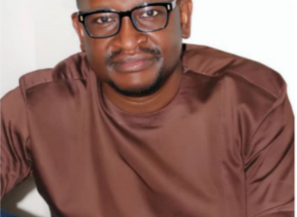 a head and shoulders photo of Collison Lore a young black man with short hair and a beard, wearing glasses and a dark brown t shirt